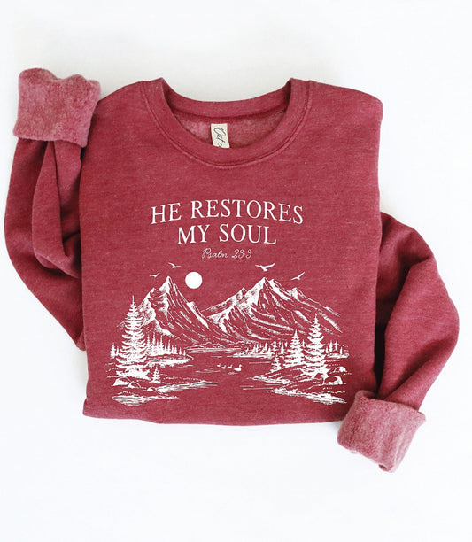 Red sweatshirt with mountain design and text on a white background. He restores my soul. Ps 23:3
